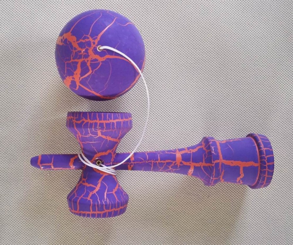 valge mustriga kendama puidust käepide ja pall ühendatud nööriga