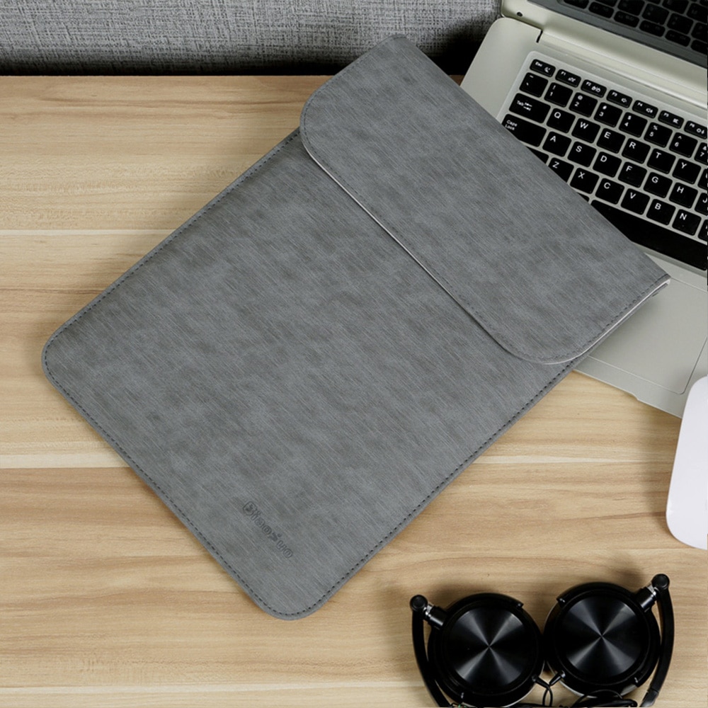 hall ja roosa macbooki ümbris laual koos avatud sülearvutiga