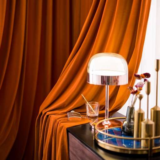 oranžid sametist kardinad, mis ripuvad elegantselt akna ees