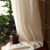 heledad retro stiilis kardinad, mis langevad elegantselt puidust lauale, taustal rohelised taimed