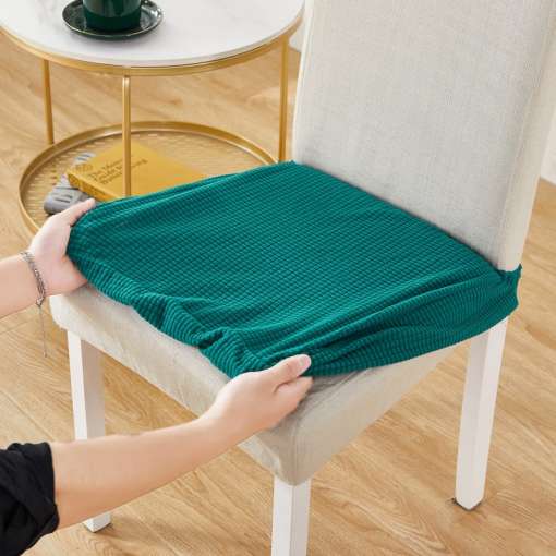inimene paigaldab rohelist elastset toolikatet valgele toolile