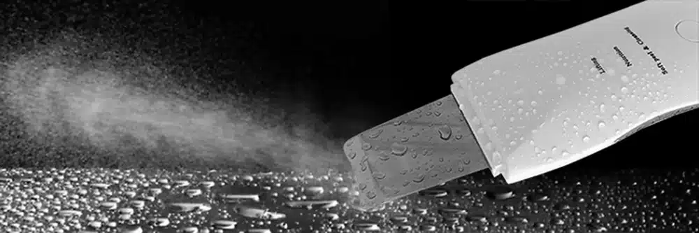 valge näomasseerija, mille metallist otsikule on kogunenud veetilgad