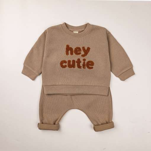 beež beebide dressikomplekt, millel on pruun kiri 'hey cutie'