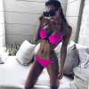naine kannab erksaid roosasid push-up bikiine, millel on mustad detailid
