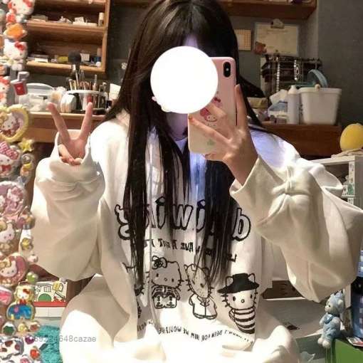 noor naine kannab valget harajuku stiilis pusat, millel on mustad illustratsioonid