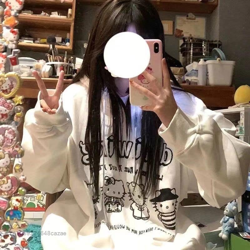noor naine kannab valget harajuku stiilis pusat, millel on mustad illustratsioonid