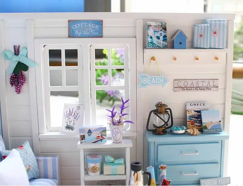 puidust miniatuurne nukumaja tuba siniste ja valgete detailidega