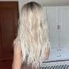 blond pikkade laineliste juustega parukas naise seljal