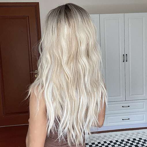 blond pikkade laineliste juustega parukas naise seljal