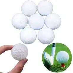 valged golfipallid, üks käes hoitud ja teised laotud
