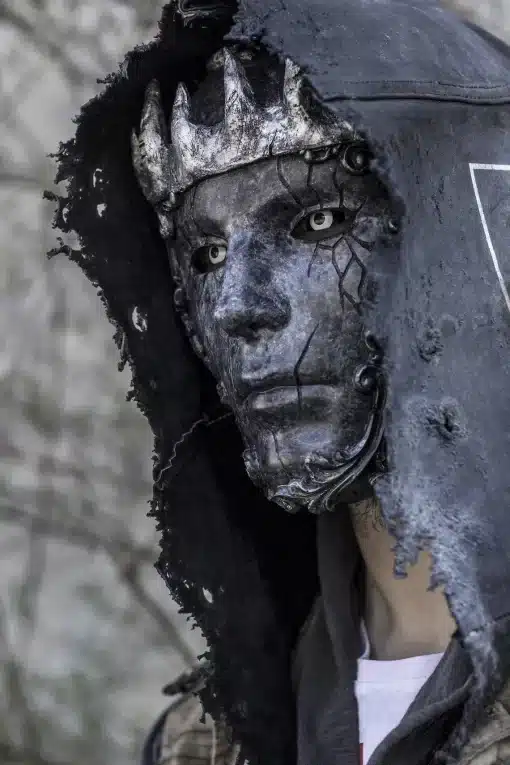tumedates toonides mask, millel on krooni meenutavad detailid ja pragunenud tekstuur