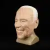 lateksist valmistatud mask, mis kujutab naeratavat vanema mehe nägu valgete juustega