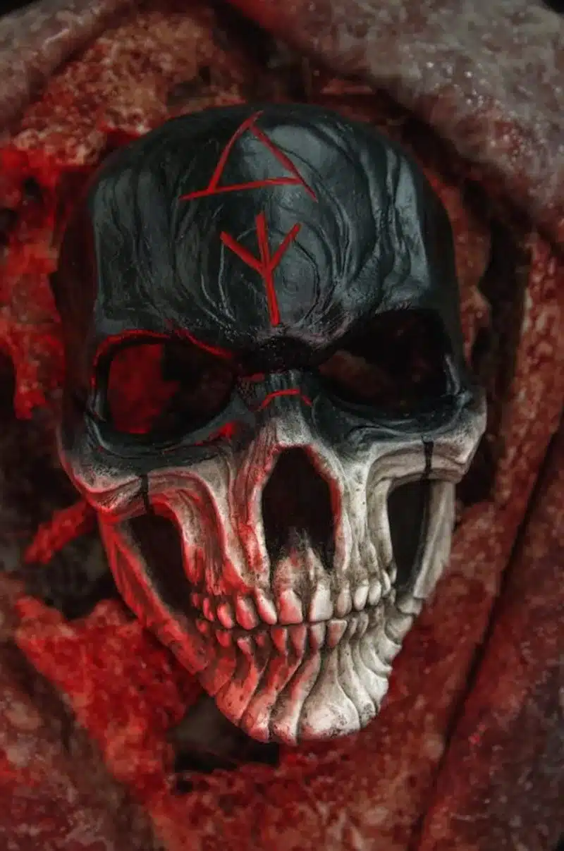 must ja valge pealuu mask punaste sümbolitega, taustal punane valgus